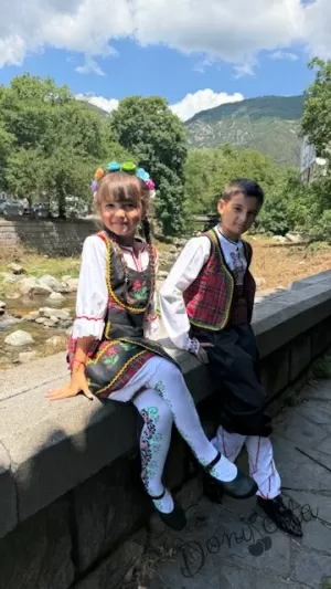 Дамска или детска народна носия за момиче 50- сукман с каре в червено, с престилка в черно с фолклорни/етно мотиви и 3/4 ръкав Карена