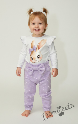 Бебешки комплект от 2 части – боди с дълъг ръкав в бяло с къдрички и лилав кант, панталон в светлолилаво на бели точки с панделка на ластика.