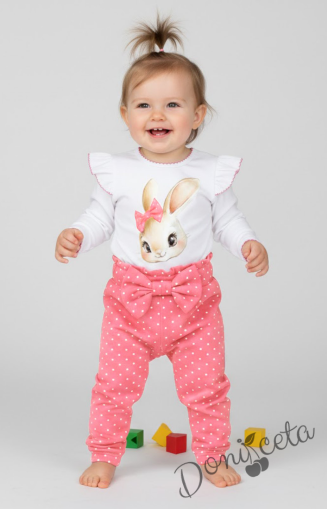 Бебешки комплект от 2 части – боди с дълъг ръкав в бяло с къдрички и розов кант, панталон в розово на бели точки с панделка на ластика.