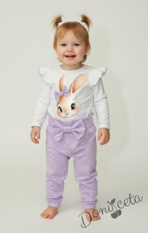 Бебешки комплект от 2 части – боди с дълъг ръкав в бяло с къдрички и лилав кант, панталон в светлолилаво на бели точки с панделка на ластика.