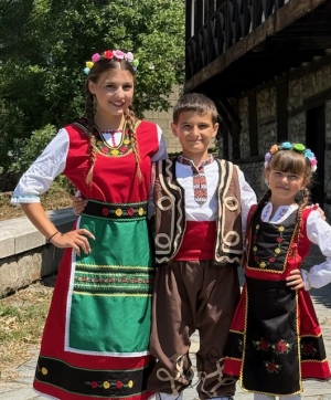 Детска народна носия 51-сукман в червено, с престилка в черно с фолклорни/етно мотиви, с дълъг ръкав